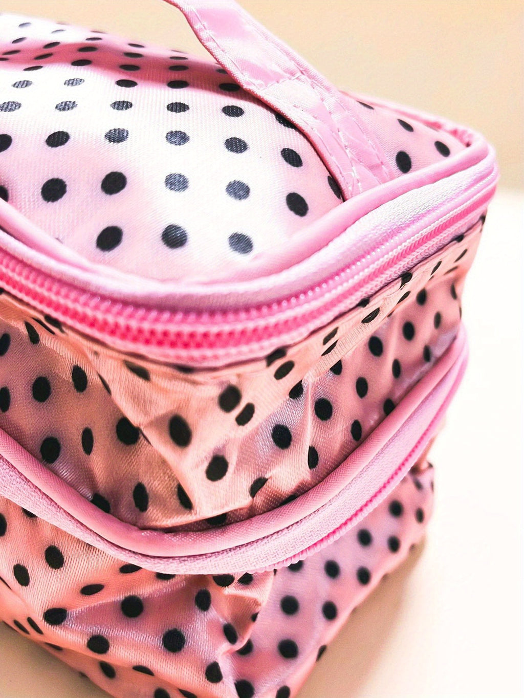 AuraNest double-layer makeup bag with pink polka dots, designed for skincare and cosmetic storage.