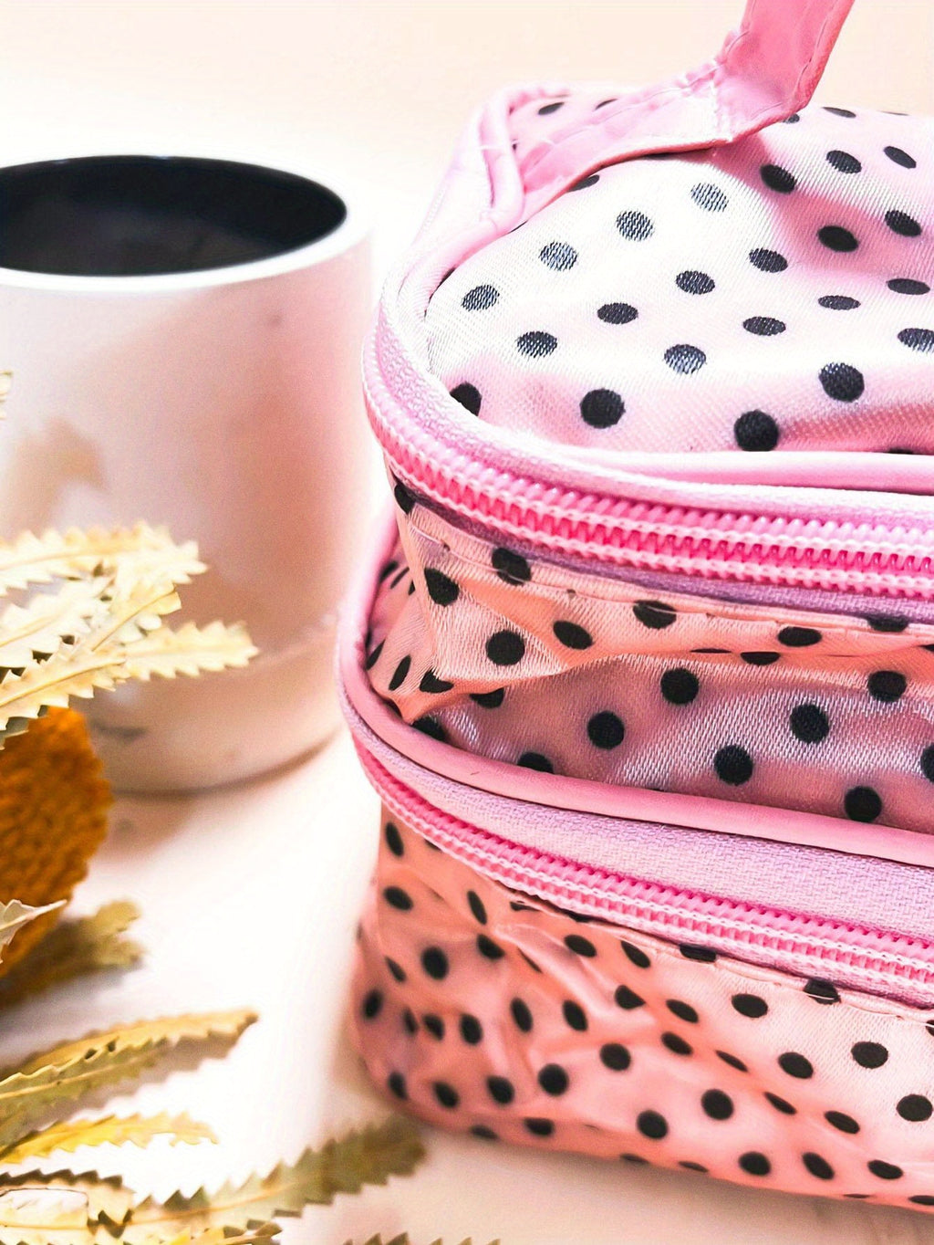 AuraNest double-layer makeup bag with pink polka dots for storing skincare products and cosmetics.