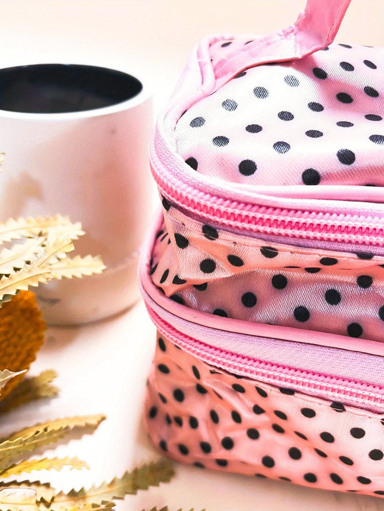 AuraNest double-layer makeup bag with pink polka dots for storing skincare products and cosmetics.